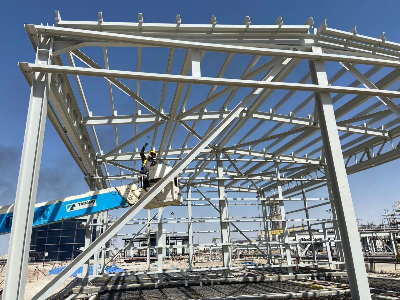 Worker on TADANO lift constructing steel frame