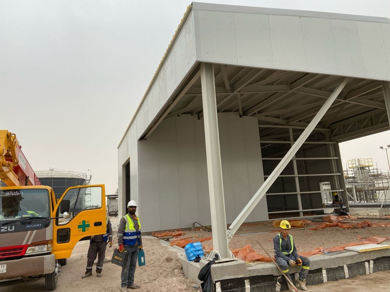 Grey building under construction with yellow ambulance