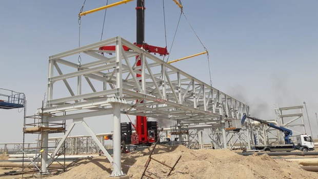 Crane lifting white steel structure frame